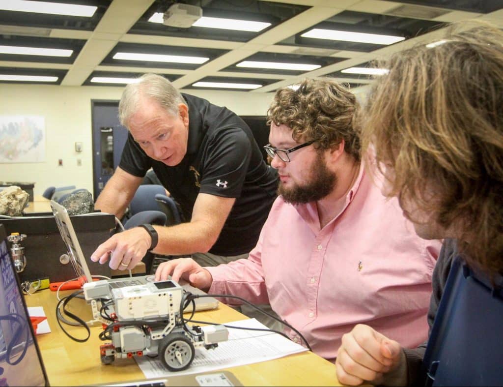 ӣֱ computer science faculty member working with students on robotics project
